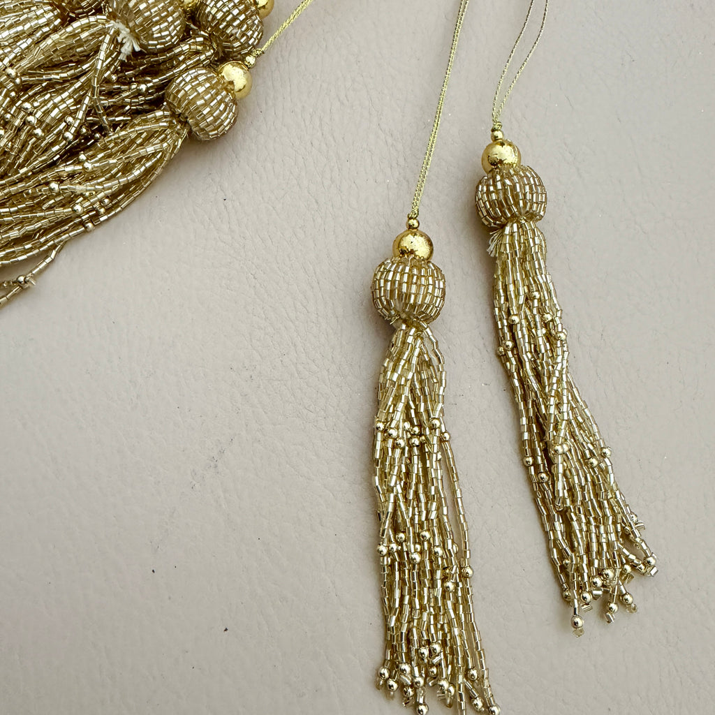 Gold tassel hanging against a light gray background