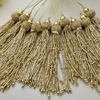 Gold tassels with beads on a light background