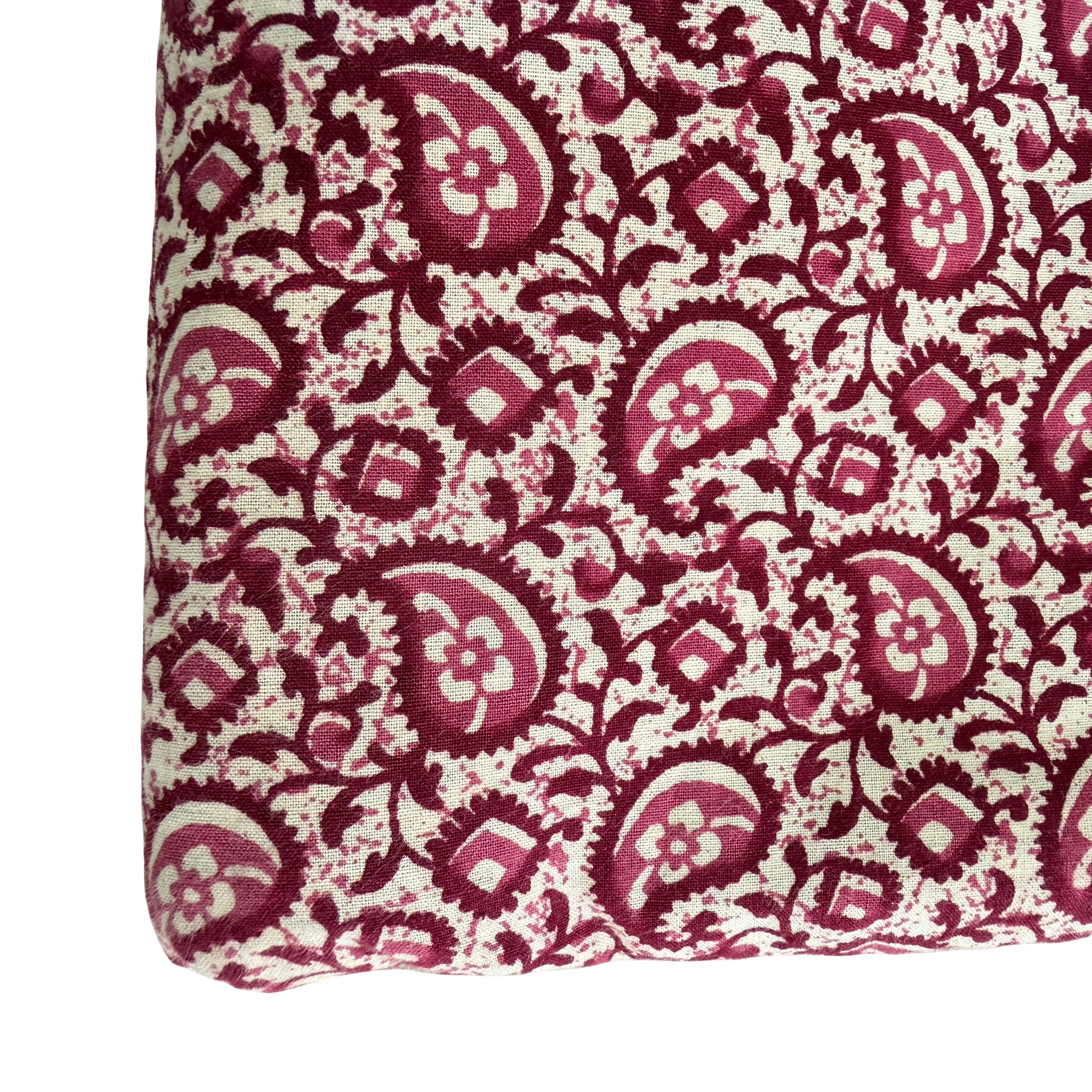 Fabric with red and beige paisley pattern on a white background