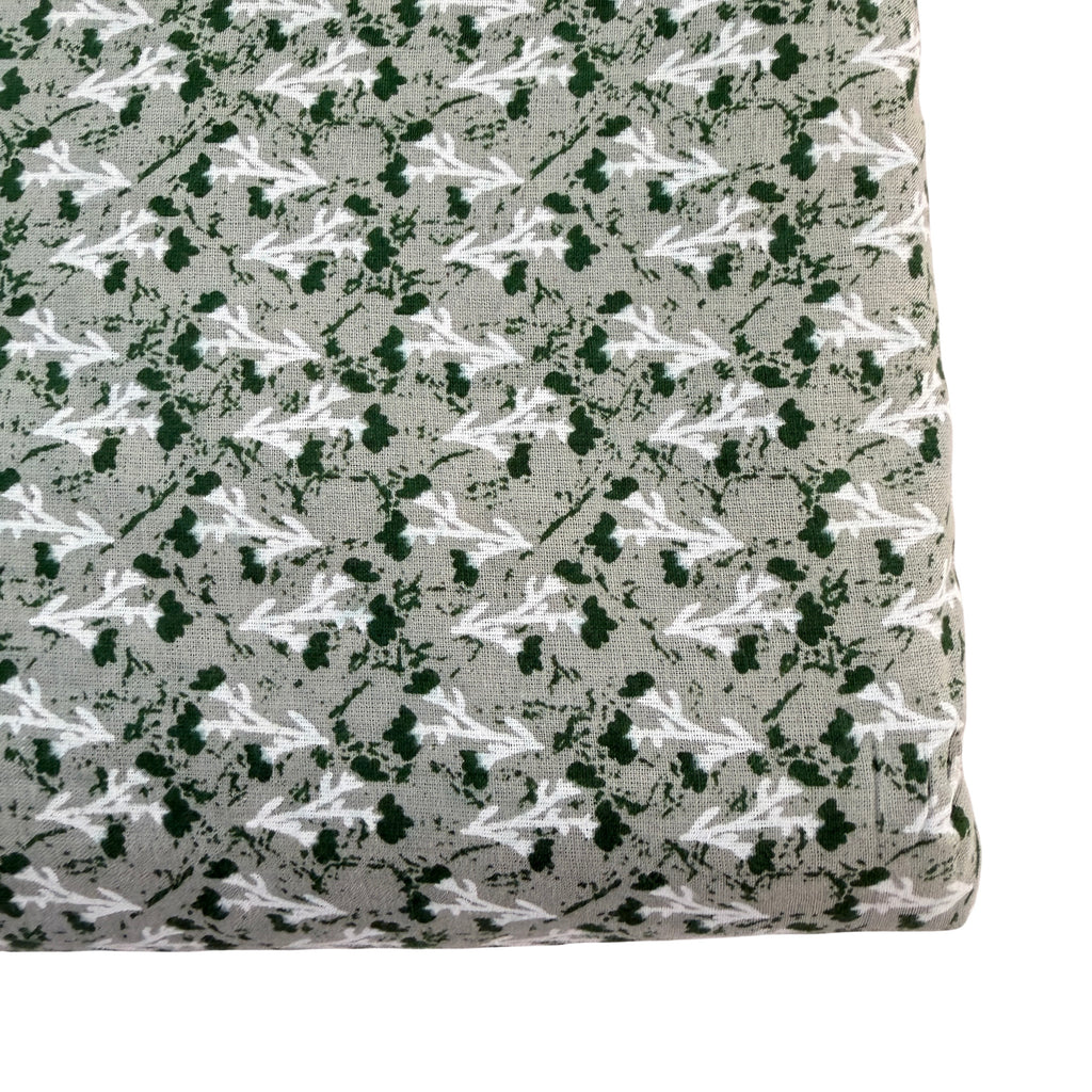Fabric with a pattern of white and green shapes on a gray background