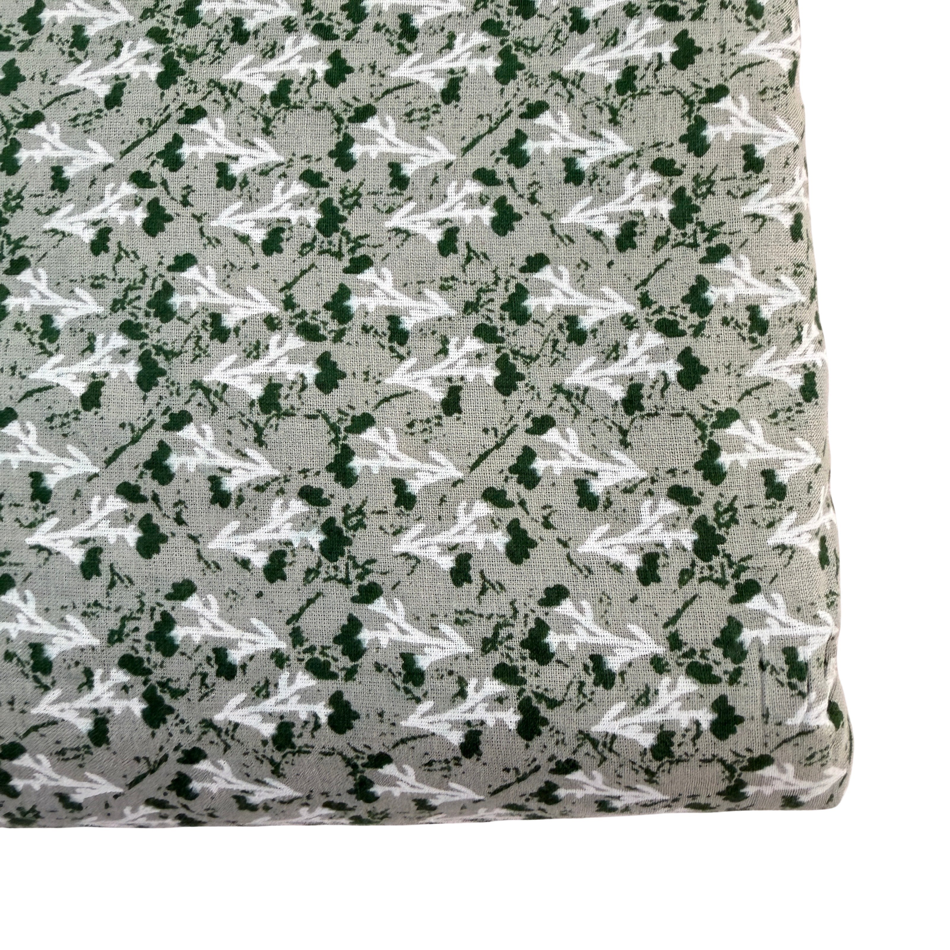 Fabric with a pattern of white and green shapes on a gray background