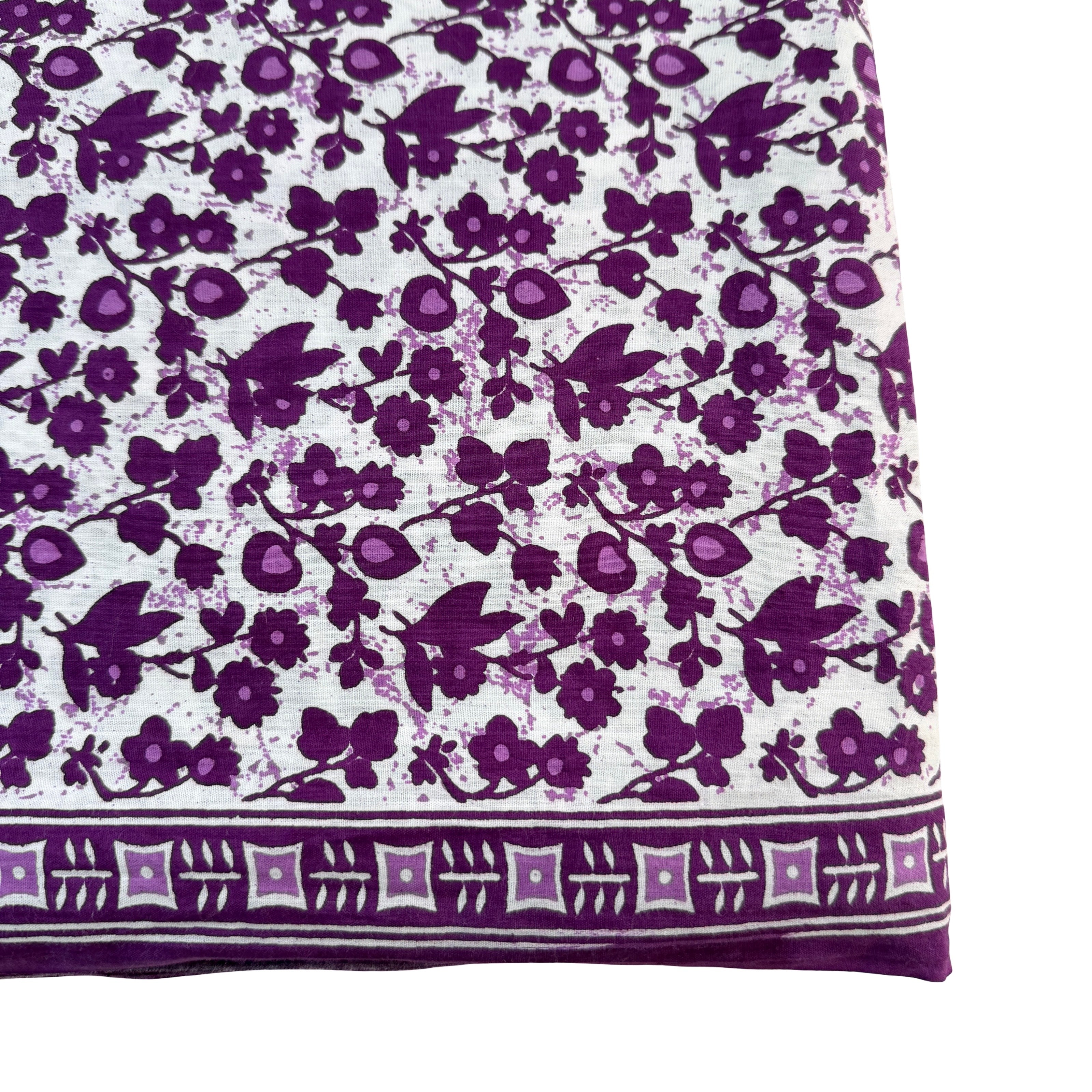 Close-up of a fabric with purple floral pattern on a white background