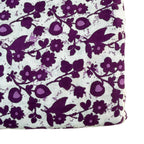 Floral and butterfly patterned fabric with purple flowers and black butterflies on a white background