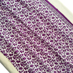 Purple floral pattern on white fabric with a border