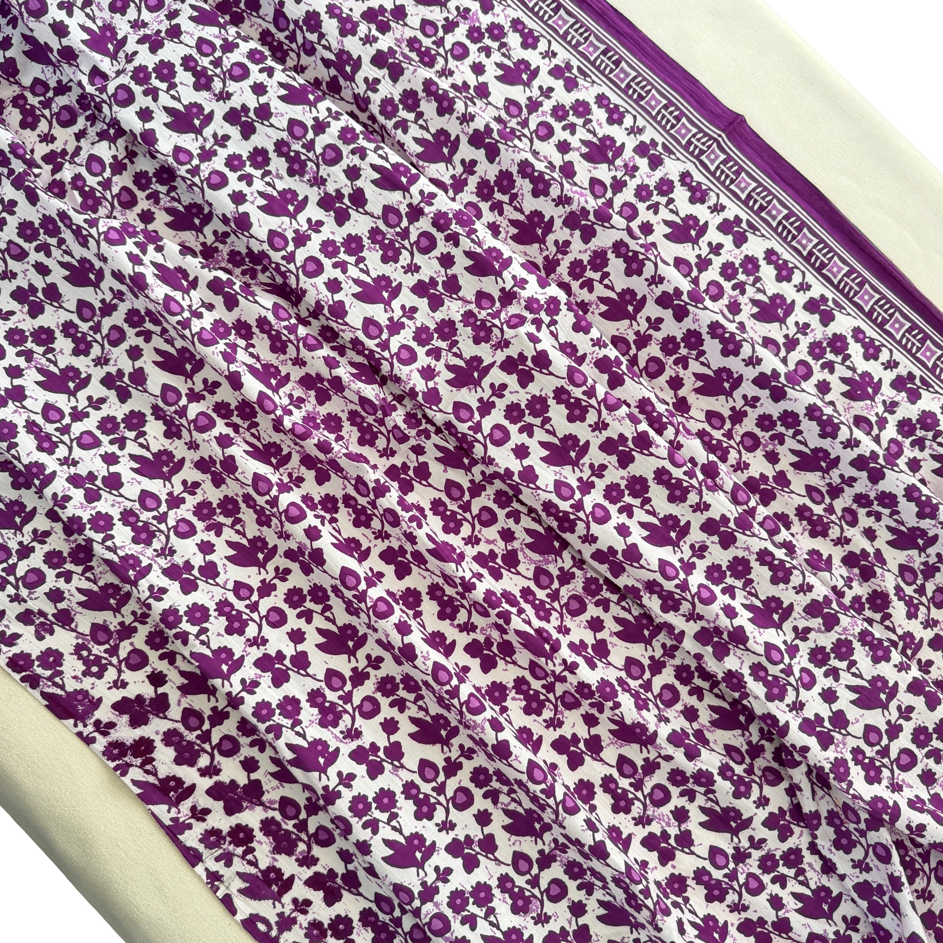 Purple floral pattern on white fabric with a border