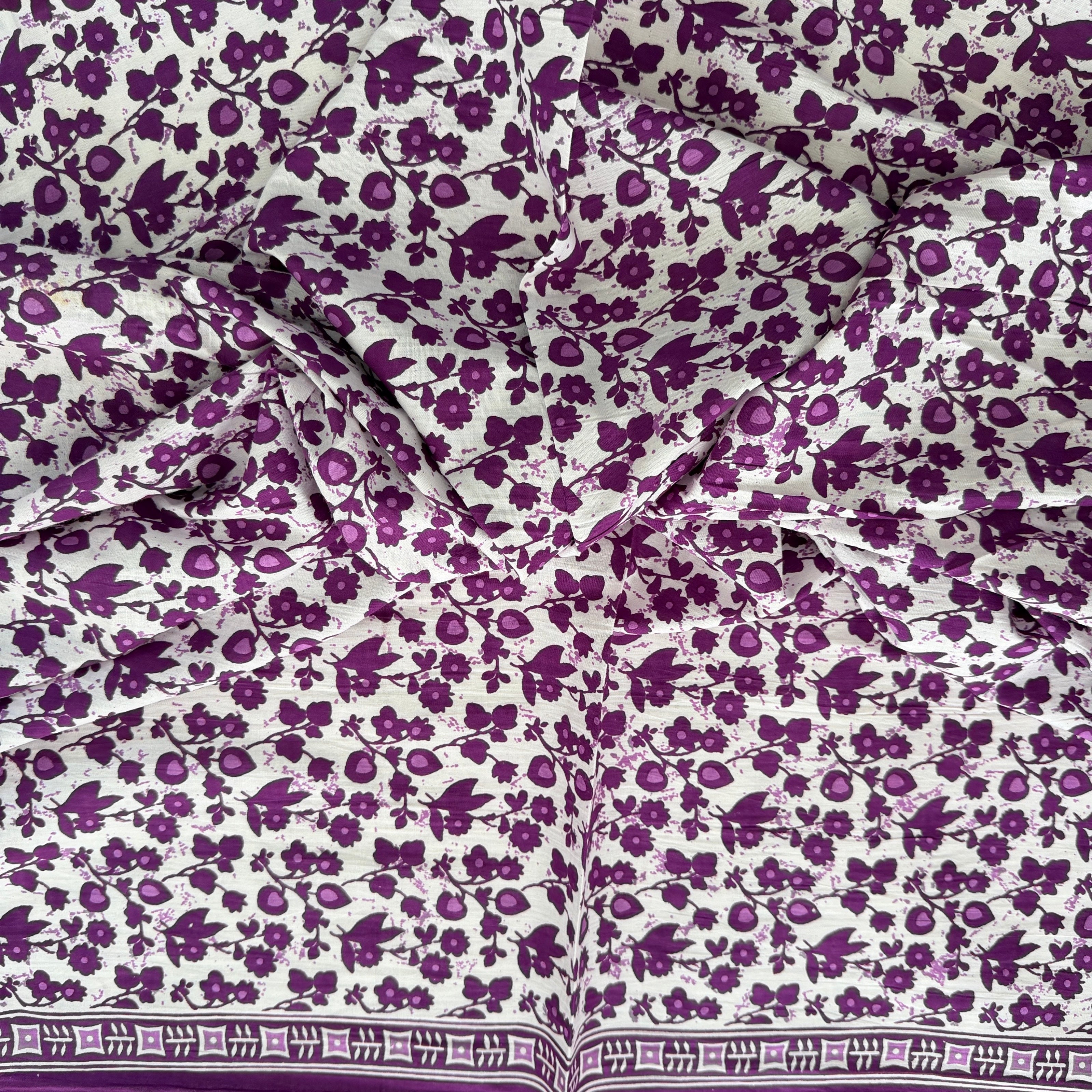 Floral patterned fabric with purple flowers on a white background