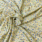 Floral fabric with small flowers in blue, yellow, and purple on a beige background