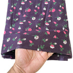 Floral-patterned fabric held by a hand on a white background