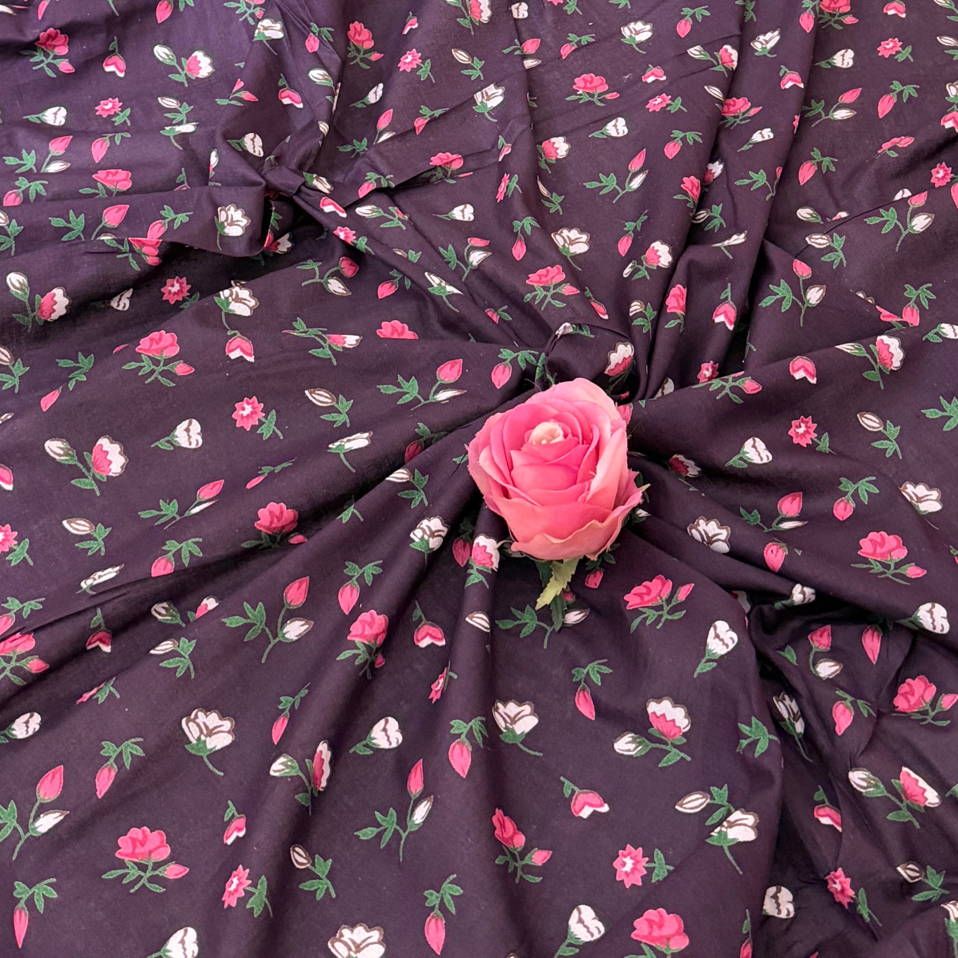 Floral fabric with pink roses on a dark background