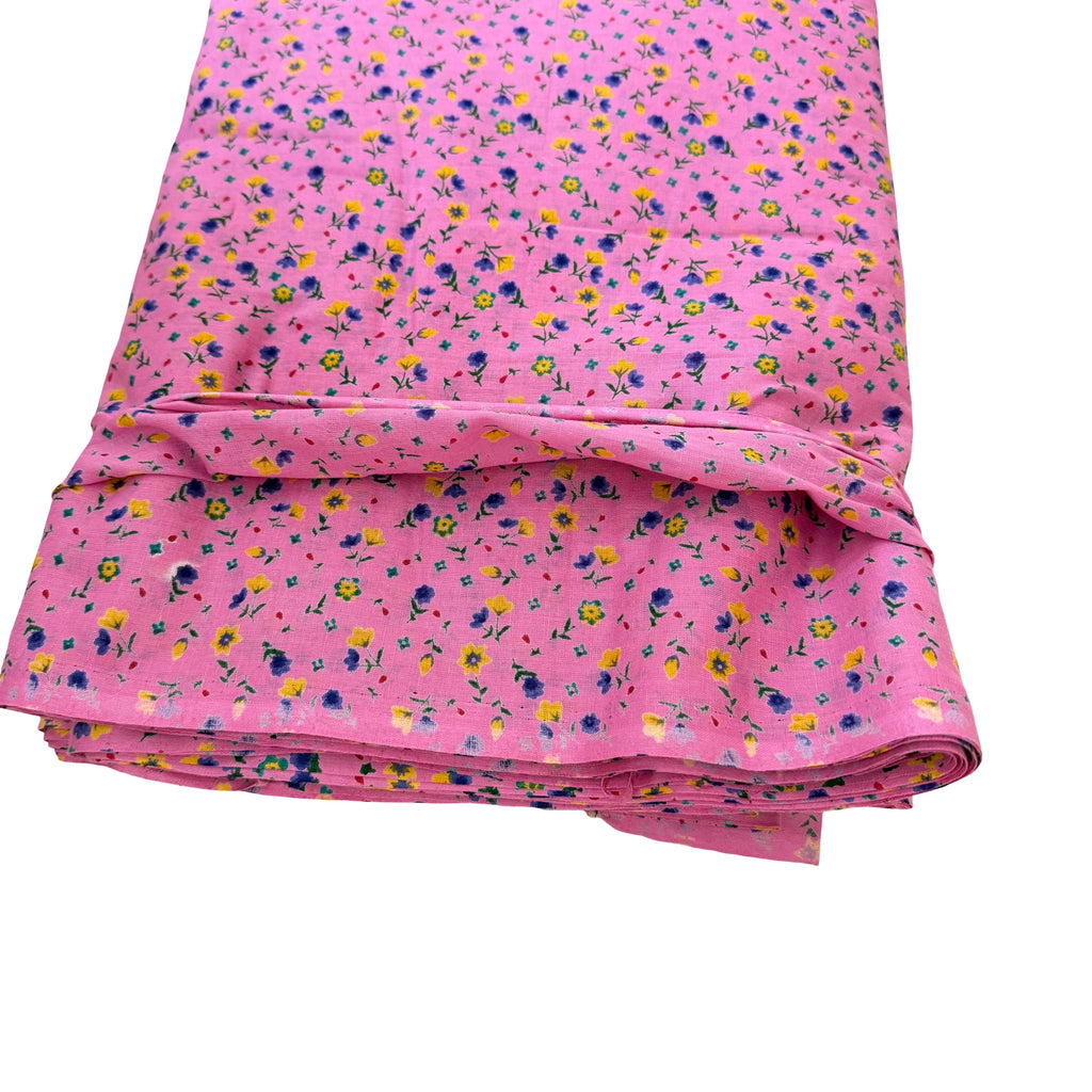 Folded pink fabric with small floral pattern on a white background