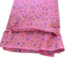 Folded pink fabric with small floral pattern on a white background