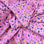 Pink fabric with small colorful floral pattern