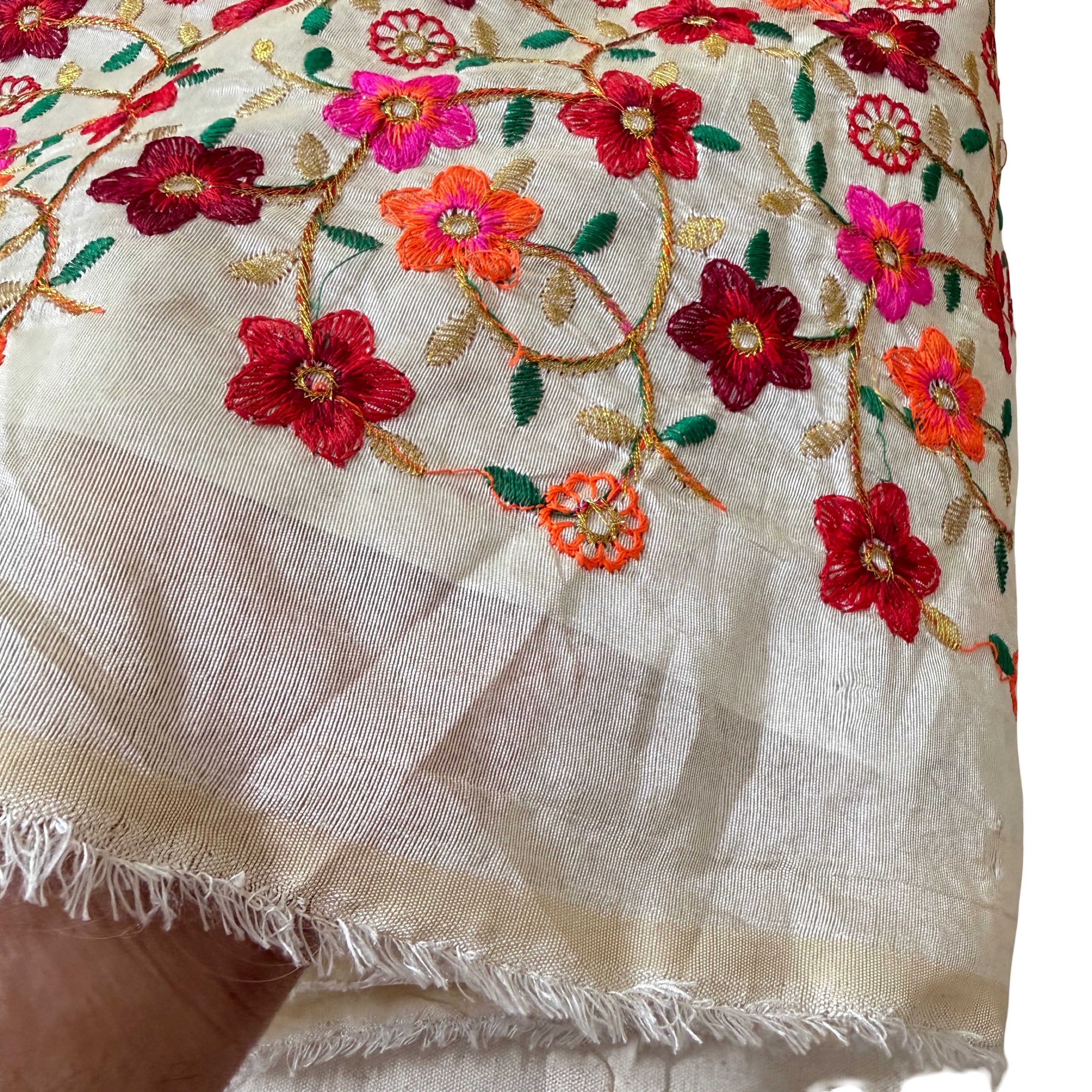 Embroidered fabric with colorful floral patterns on a beige background