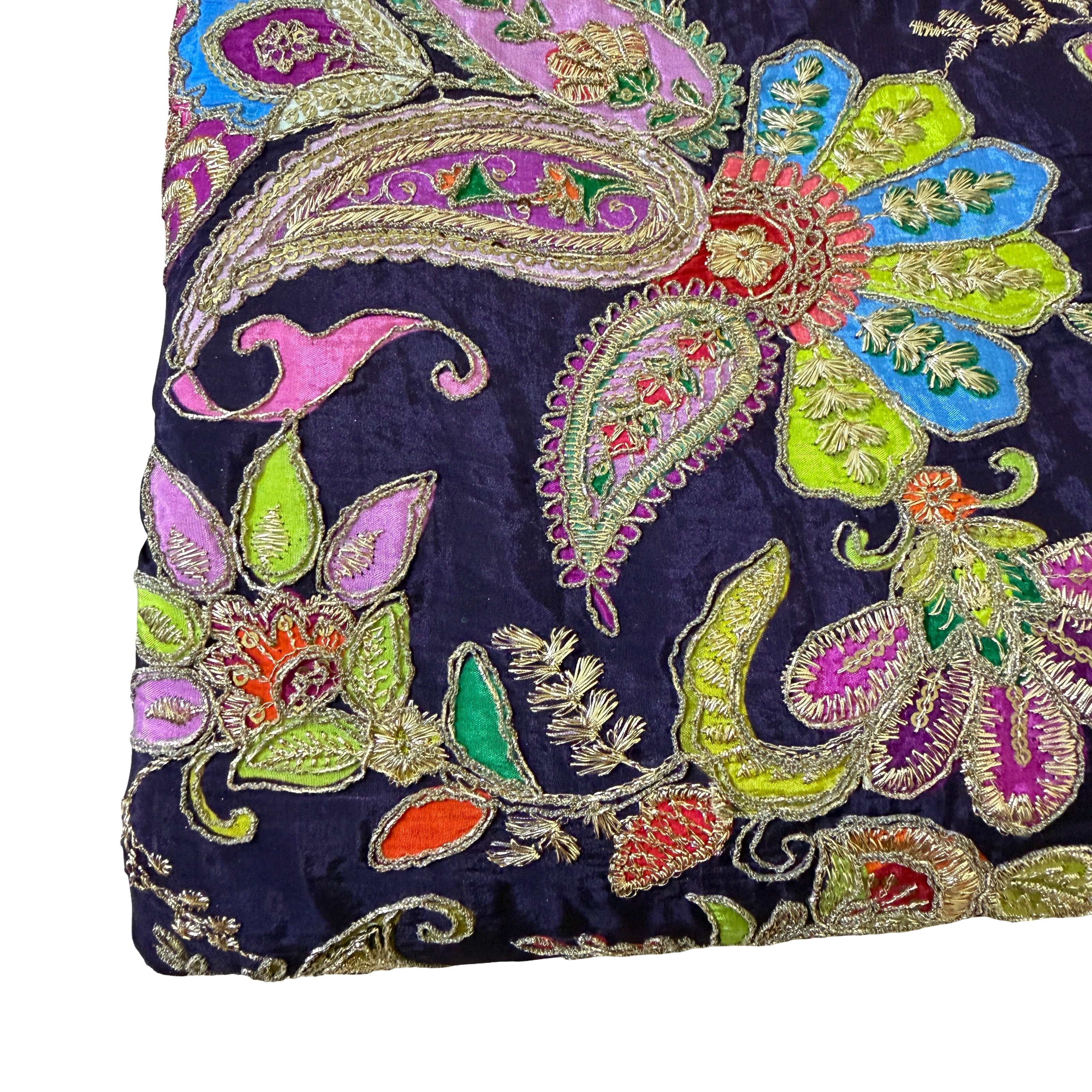 Embroidered fabric with colorful paisley patterns on a dark background