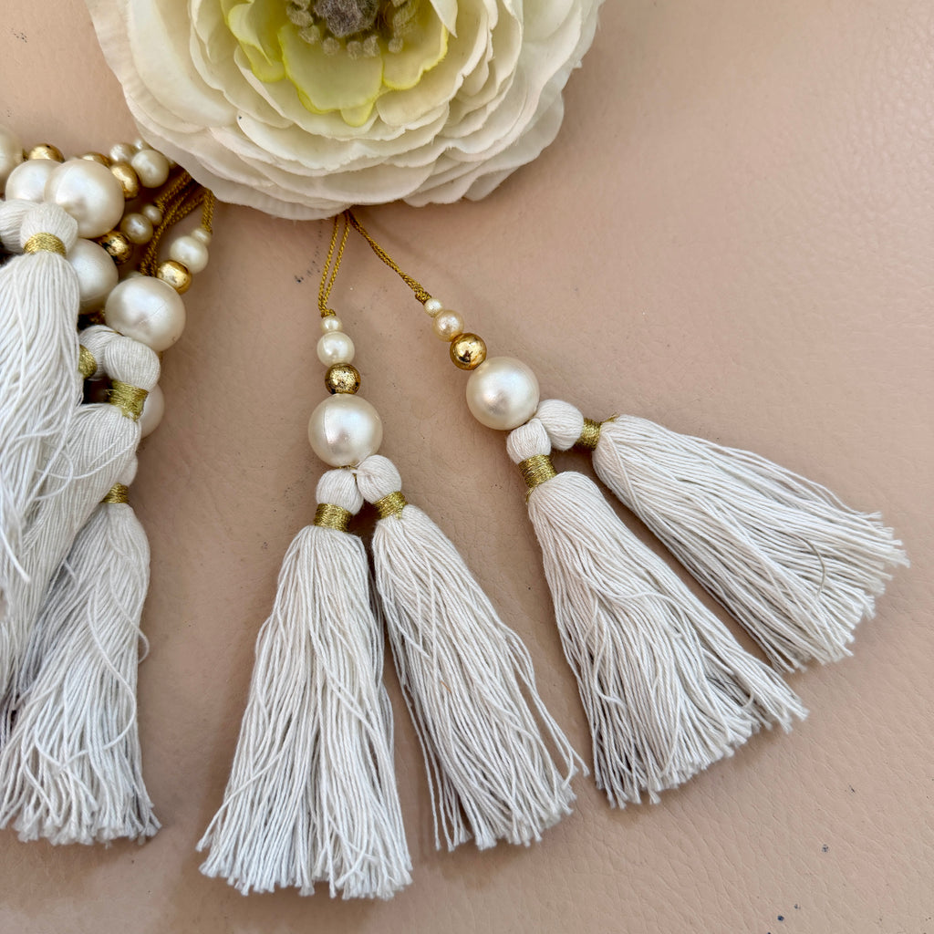 Necklace with white tassels and pearls on a person's neck