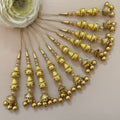 Gold hair accessories with decorative beads on a neutral background