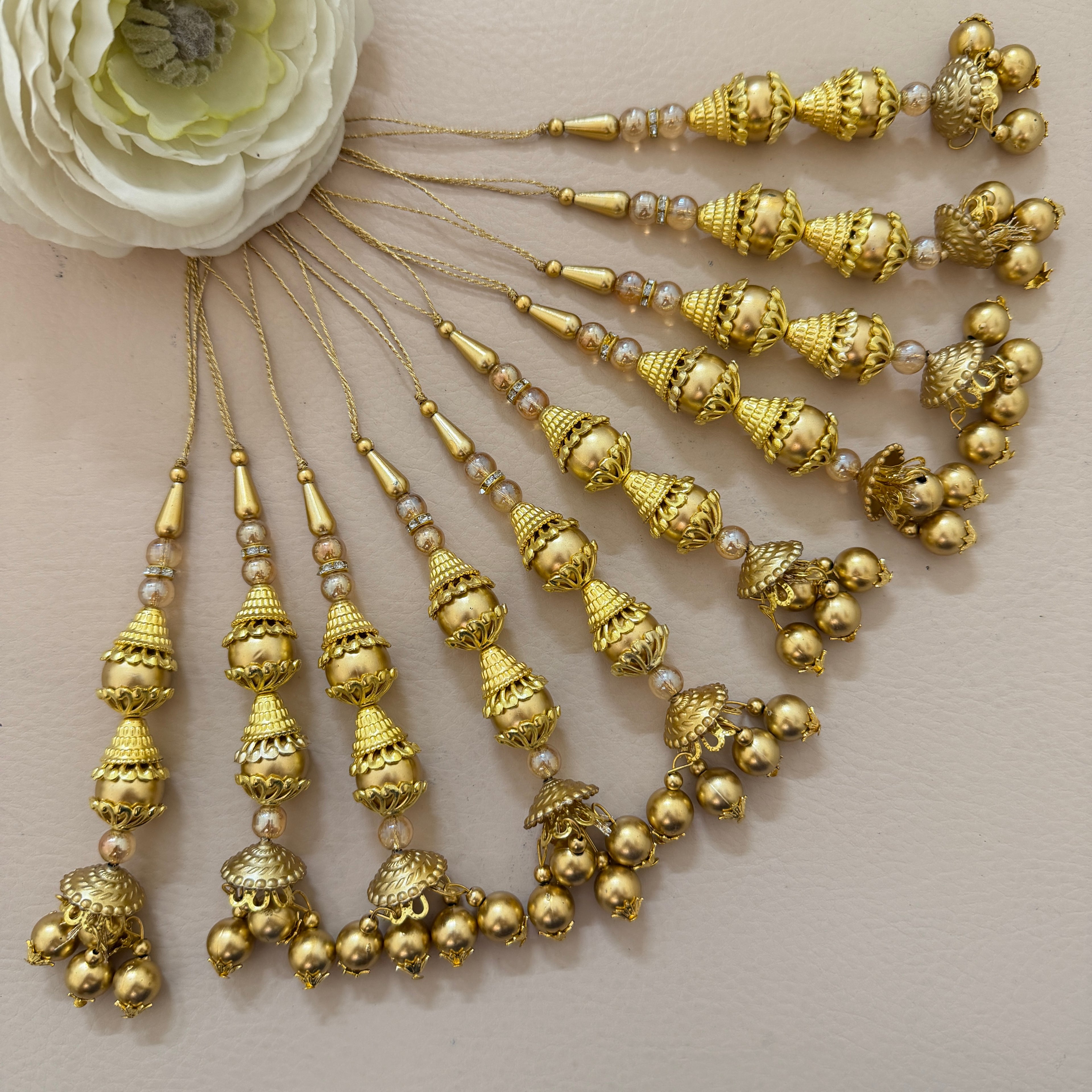 Gold hair accessories with decorative beads on a neutral background