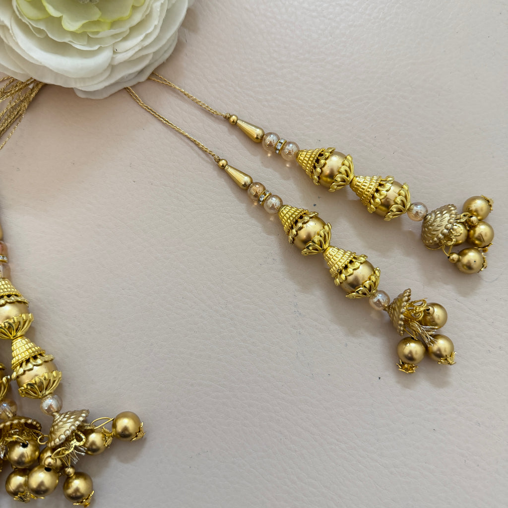 Gold necklace with decorative elements on a light background