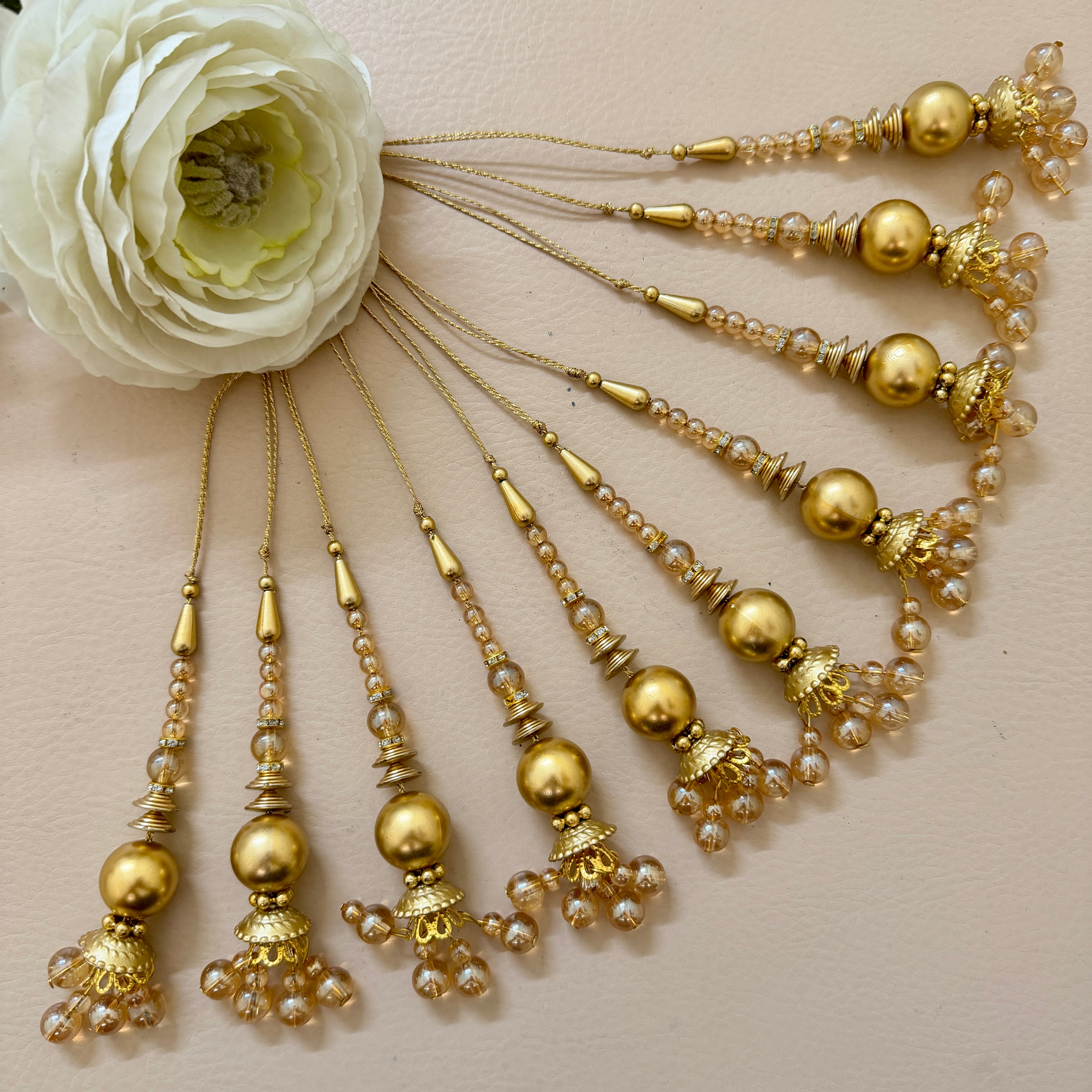 Set of gold hairpins with beads and pearls on a beige background