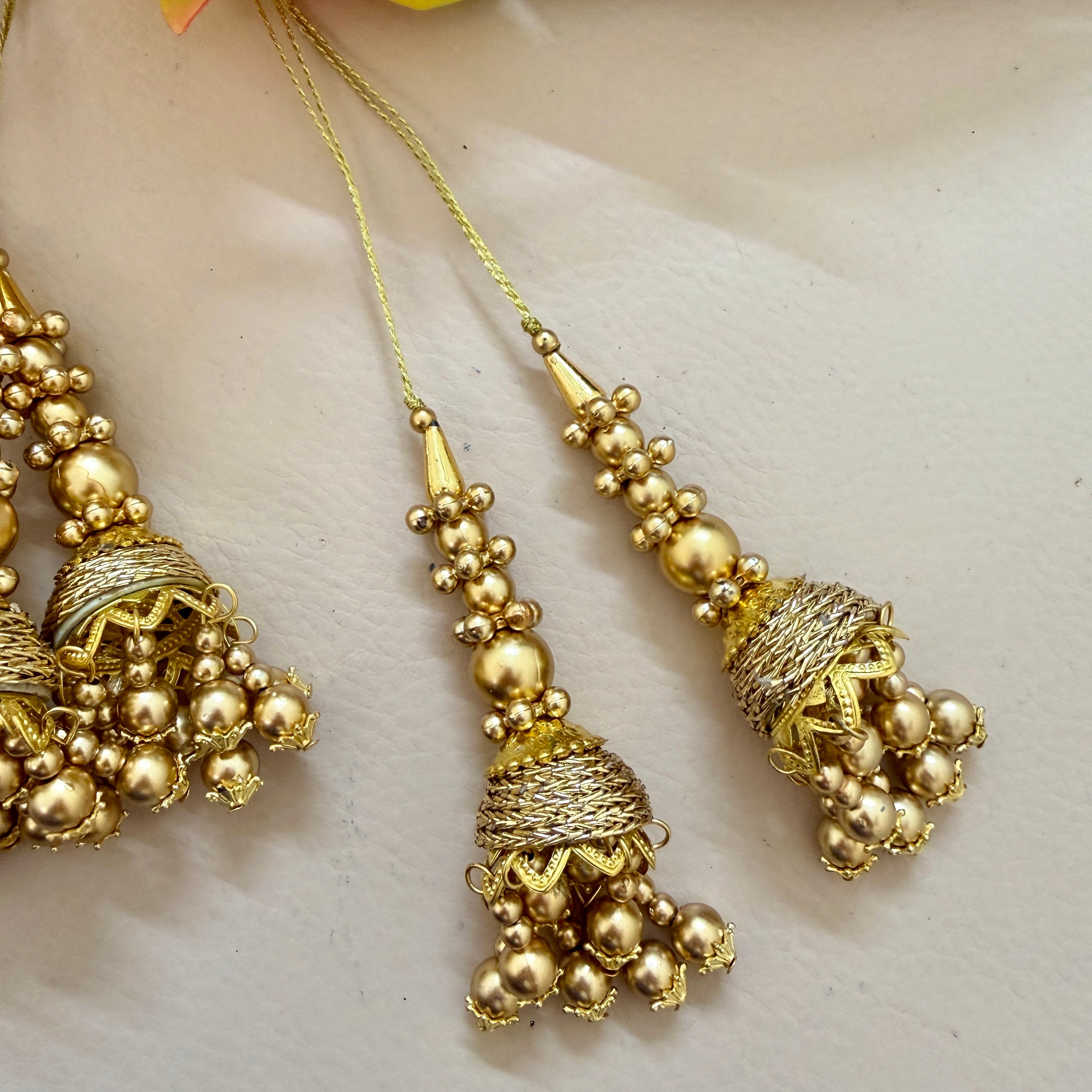 Gold jewelry set with intricate designs on a light background
