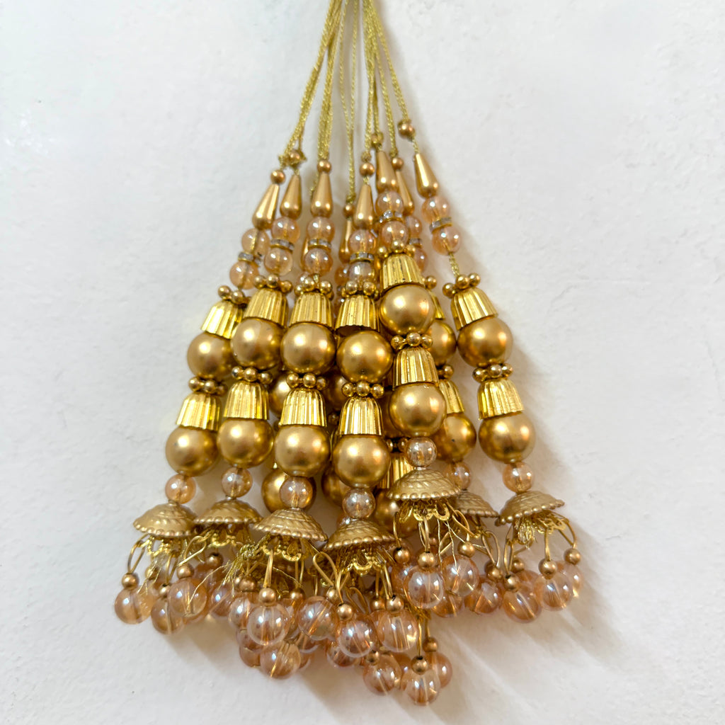 Gold and pearl beaded hanging ornament on a white background