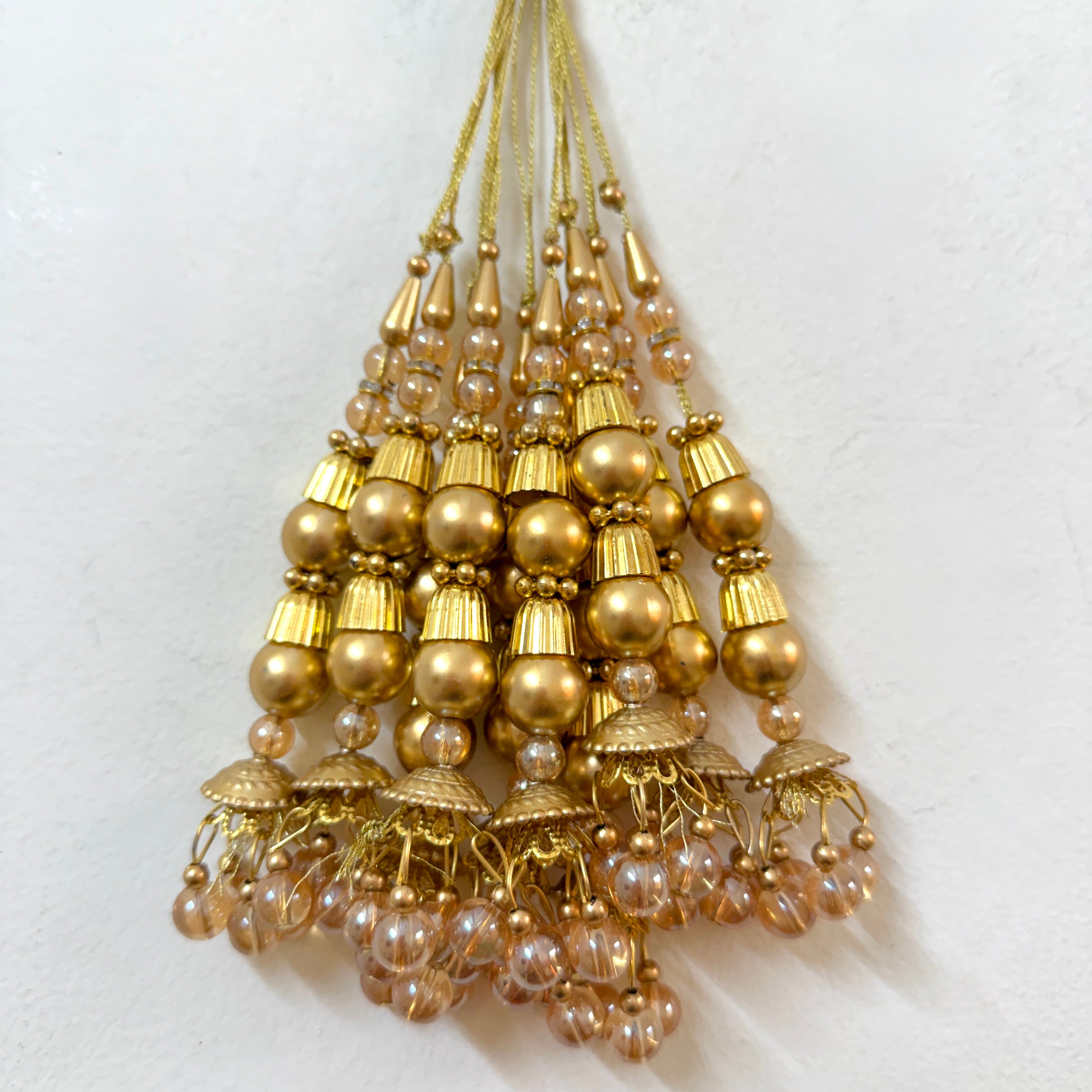 Gold and pearl beaded hanging ornament on a white background
