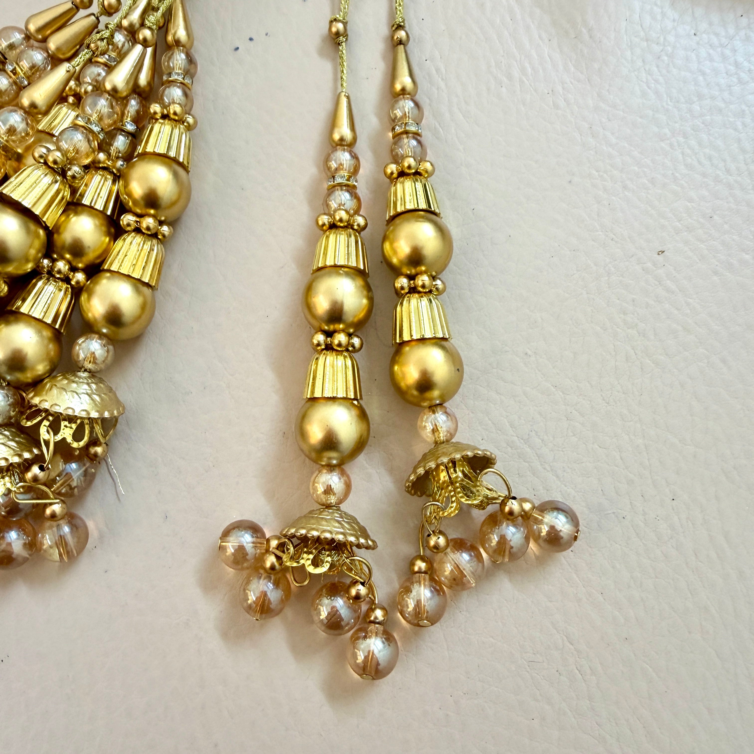 Gold and pearl earrings on a light background