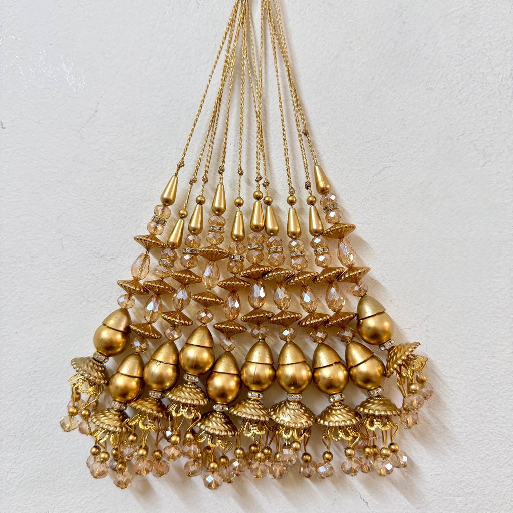 Gold beaded chandelier on a light gray background
