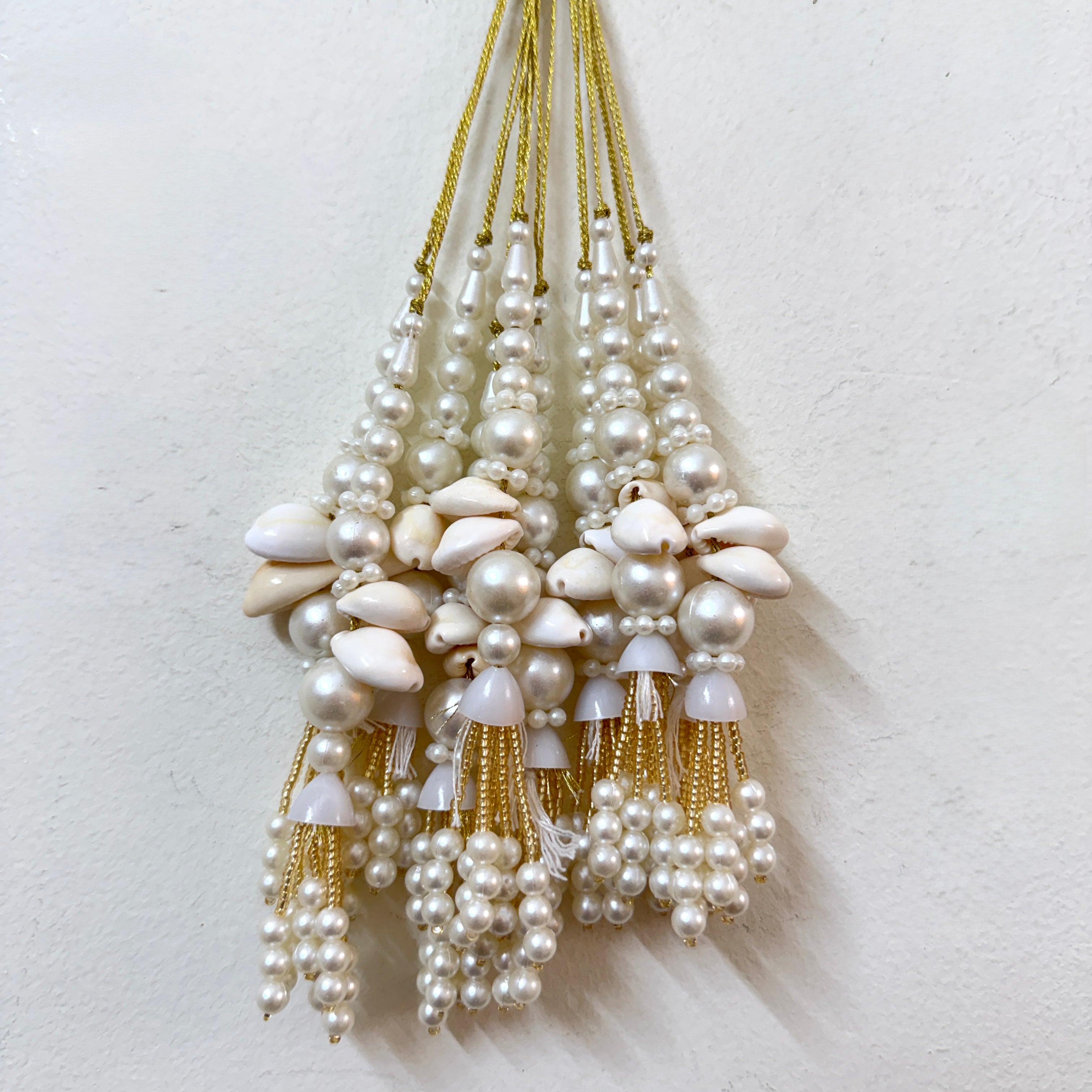 Pearl and shell tassel necklace on a white background