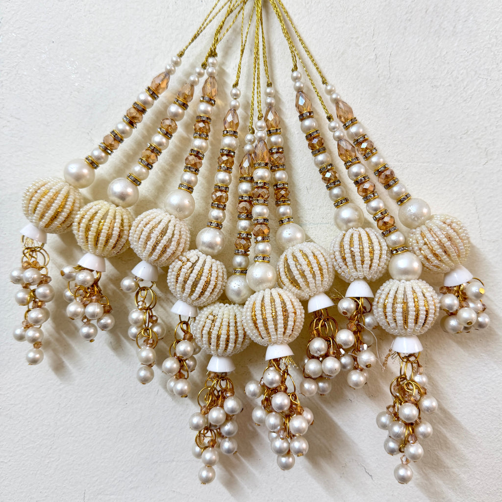 Beaded jewelry with pearls and gold accents on a light background
