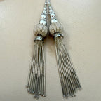 Pair of silver tassel earrings on a light background