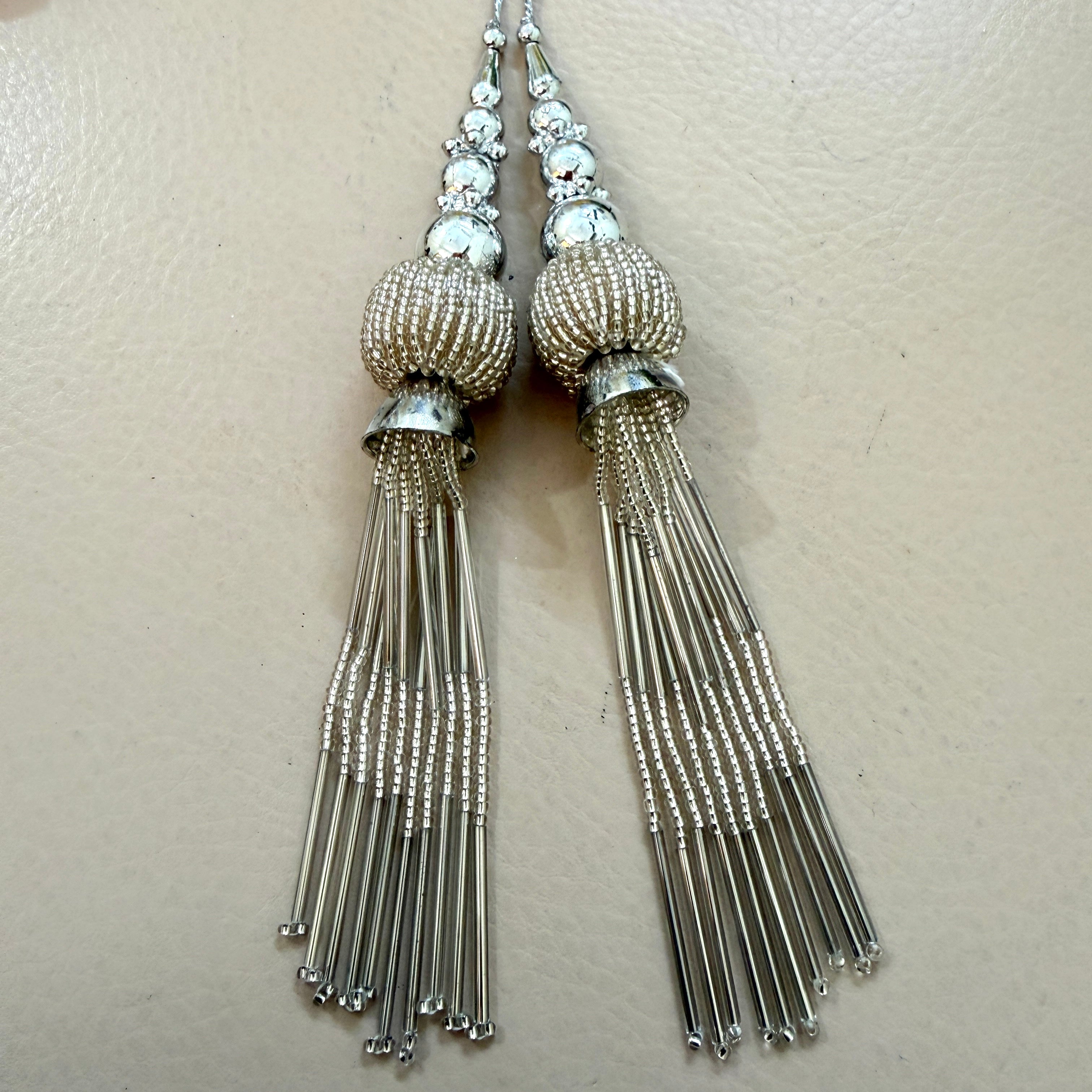Pair of silver tassel earrings on a light background