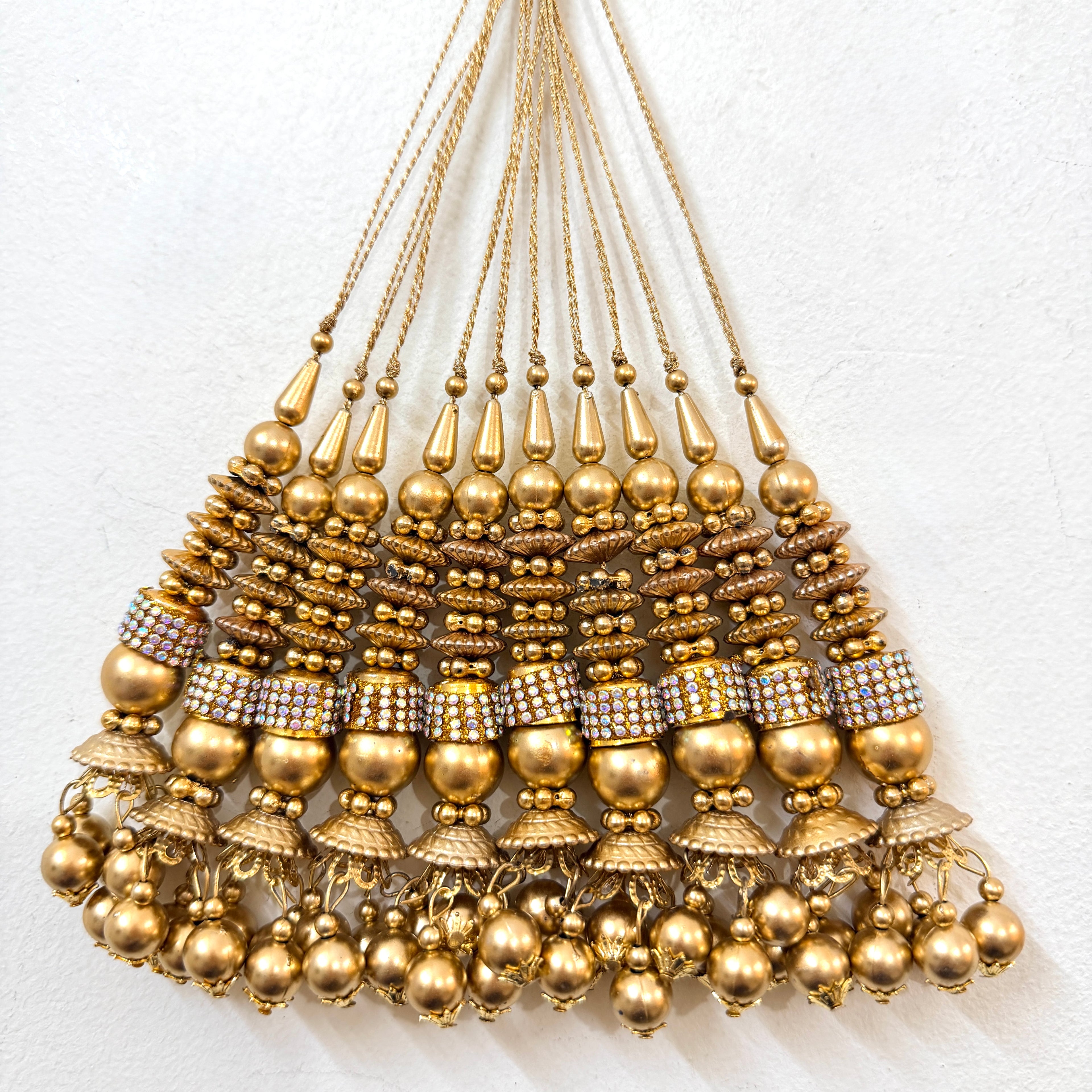 Gold necklace with beads and pendants on a white background