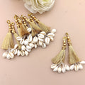 Decorative keychain with tassels and cowrie shells on a beige background