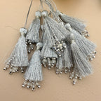 Decorative tassels with beads on a beige background