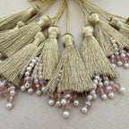 Gold tassels with pearls and beads on a light background