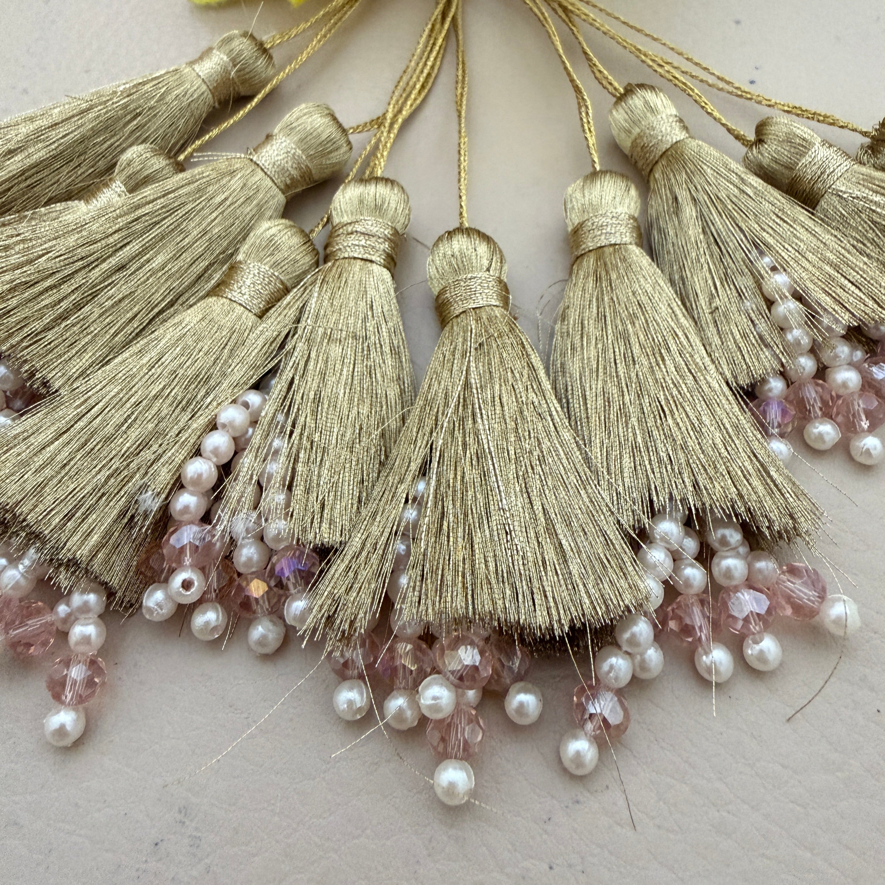 Gold tassels with pearls and beads on a light background