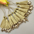 Gold tassels with beads on a light gray background