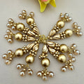 Gold and pearl decorative piece on a light background