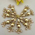 Gold and pearl decorative piece on a light background