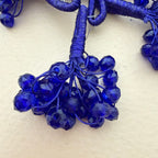 Close-up of blue beads and string on a light background