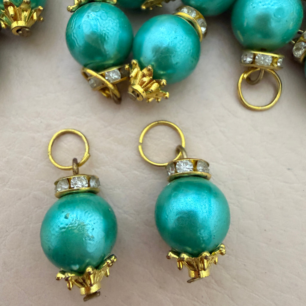 Turquoise pearl earrings with gold and diamond accents on a light background
