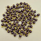 Purple pearls with gold accents on a beige background