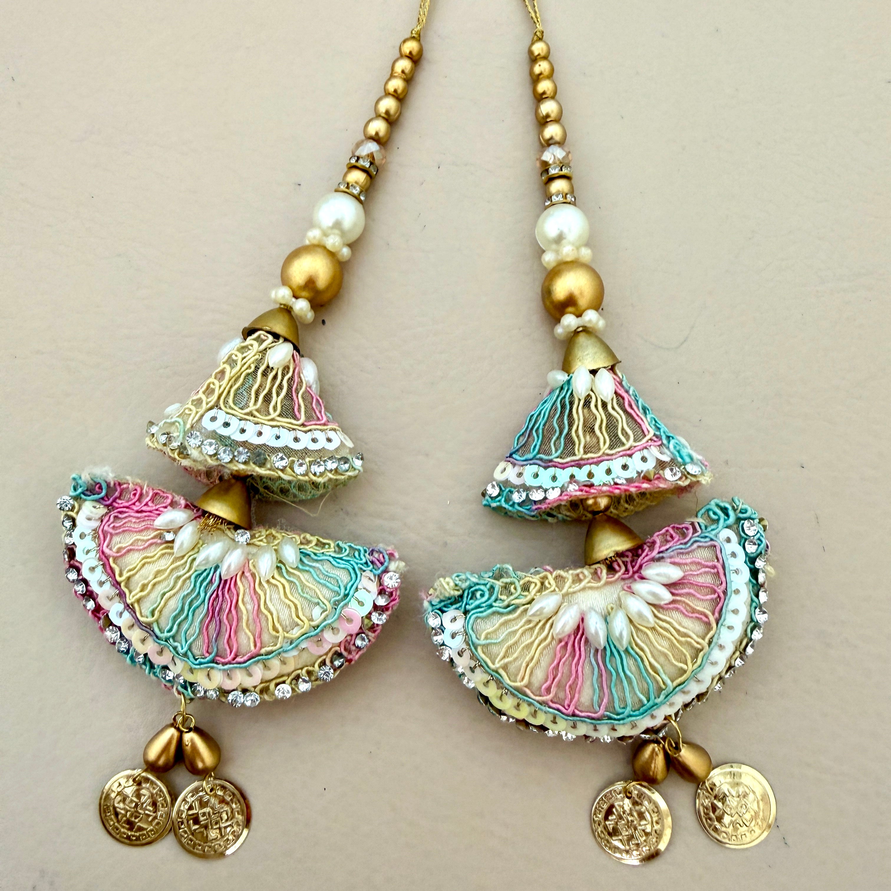 Colorful earrings with gold accents on a beige background