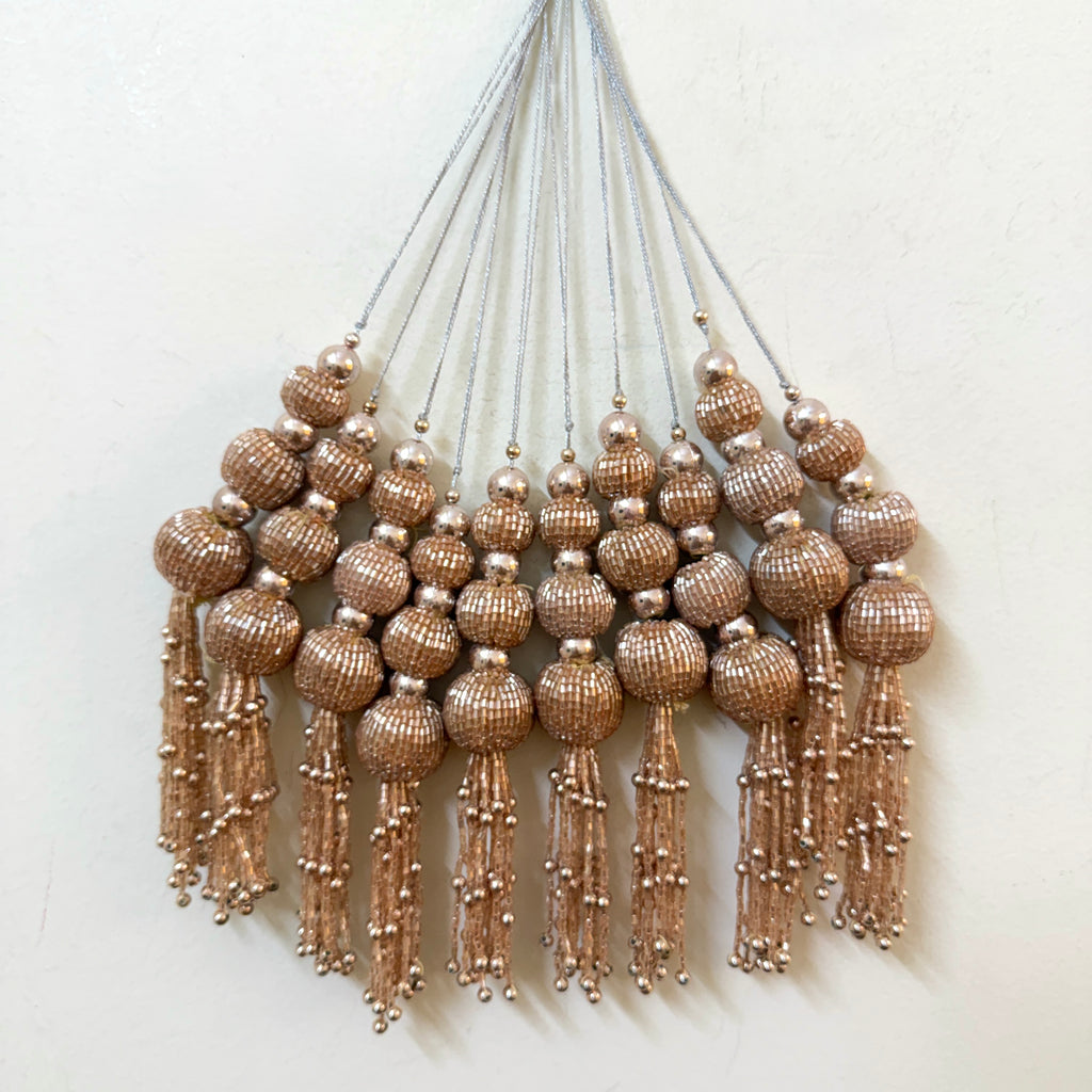 Decorative wall hanging with beaded tassels on a white background