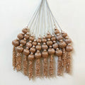 Decorative wall hanging with beaded tassels on a white background