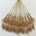 Set of gold and beige beaded tassels on a textured white background