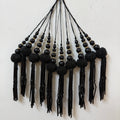Black beaded tassel necklace on a light background