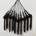 Black beaded tassel necklace on a light background