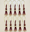 Set of red and gold tassel decorations on a beige background